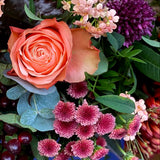 Colorful bouquet of flowers with roses and other varieties on a reflective surface