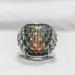 Decorative candle holder with a textured surface on a white background