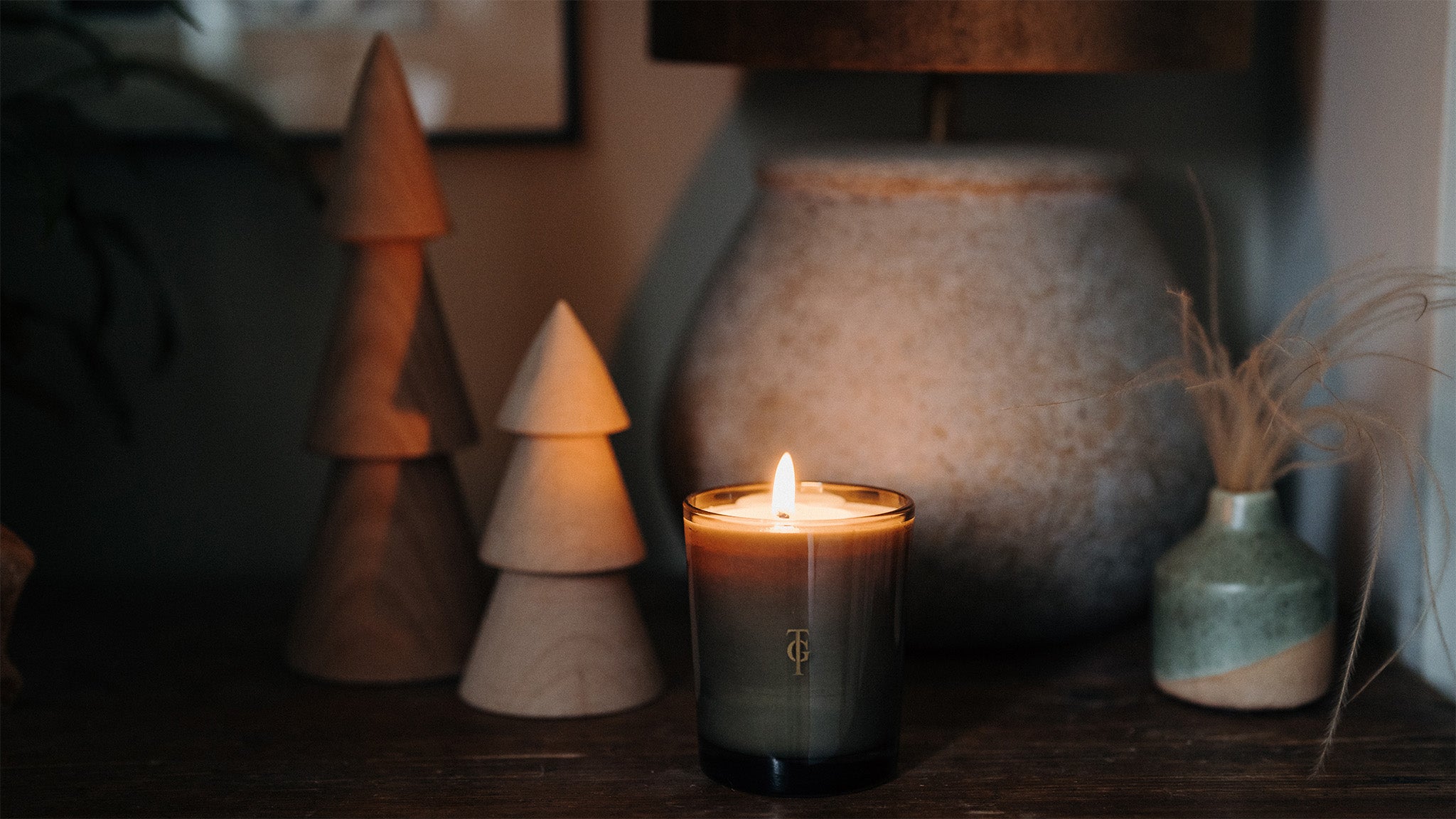 A scented candle adds a warming soft ambiance to a bedside table