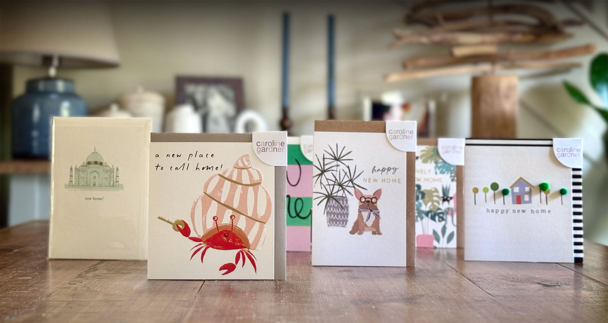 Set of New Home greeting cards on a wooden surface with a blurred indoor background