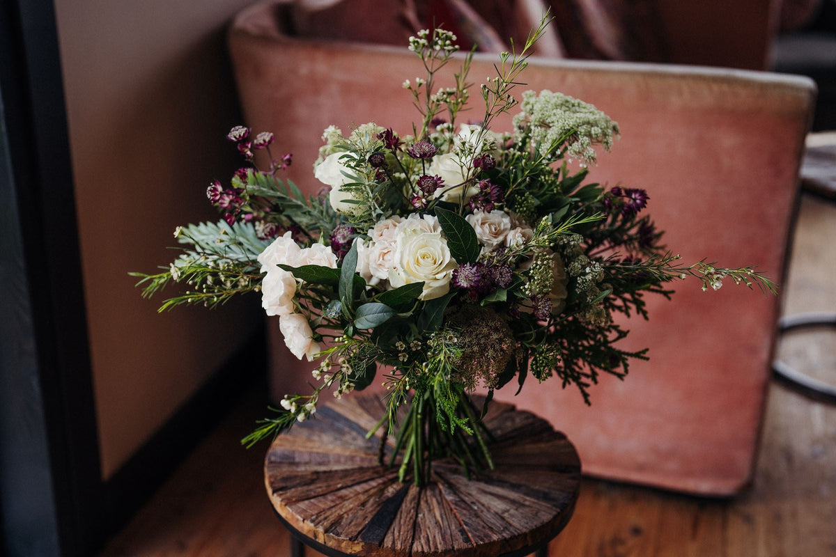 The Midnight Pearl luxury white winter hand-tied bouquet featuring White Tibet roses, lisianthus, waxflower and pussy willow, created by Mad Lilies florists.