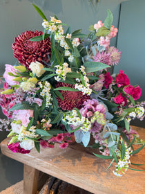October Bouquet of the Month with burgundy flowers, hot pink roses, snowberry, eryngium and eucalyptus