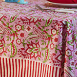 Pink floral block print cotton tablecloth with red and white candy stripe border styled for elegant dining and entertaining.