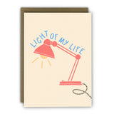 Modern anniversary card featuring a desk lamp illustration and the message "Light of My Life", printed on premium textured ivory cardstock with a kraft envelope.