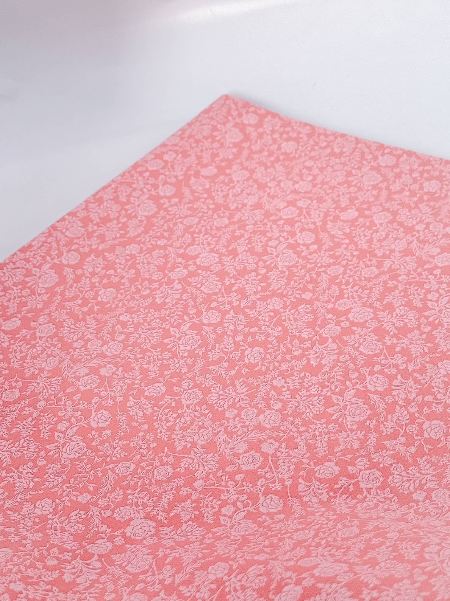 Pink tissue paper with a subtle pattern on a white background
