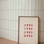 Framed artwork with red Good Food Good Mood text on a beige background against a tiled wall.