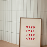 Framed artwork with red Good Food Good Mood text on a beige background against a tiled wall.