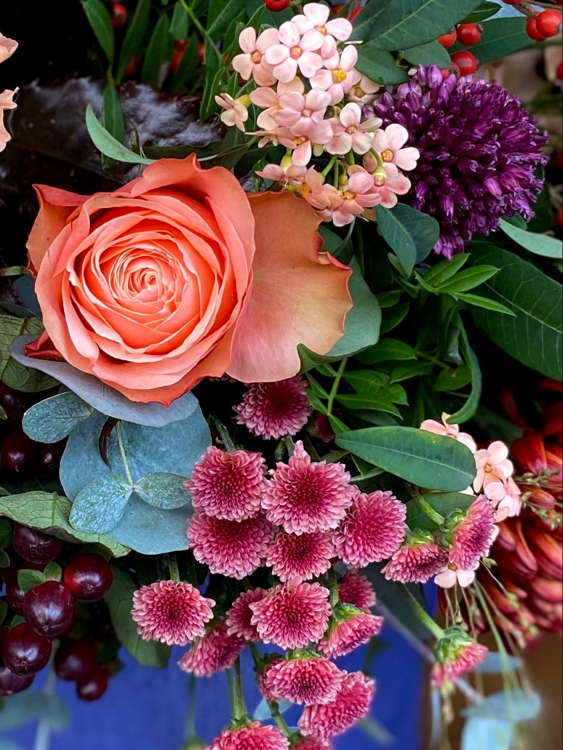 Colorful bouquet of flowers with roses and other varieties on a reflective surface