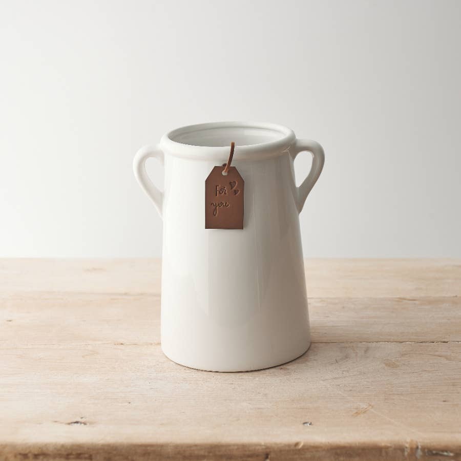 White ceramic vase with handles and tag