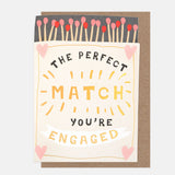 The Perfect Match engagement card featuring a die-cut matchbox with pink and red matches and gold foil detailing.