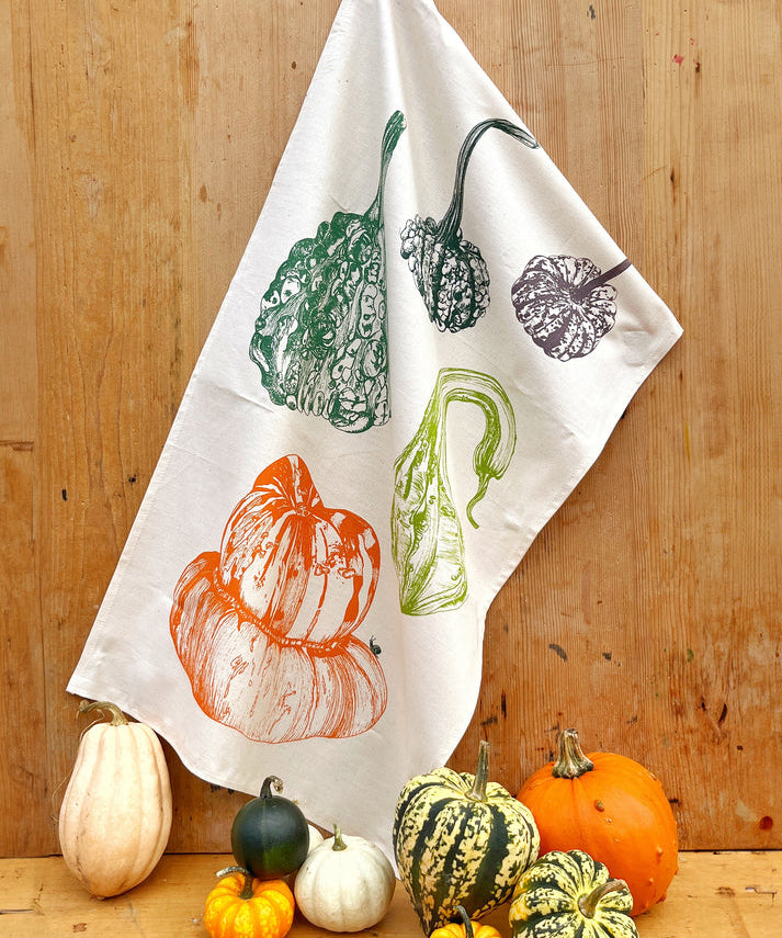 Tea towel with autumnal design of pumpkins and gourds 