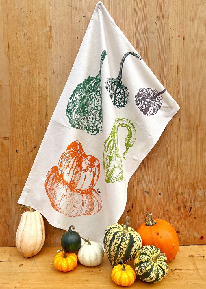 Tea towel with autumnal design of pumpkins and gourds 