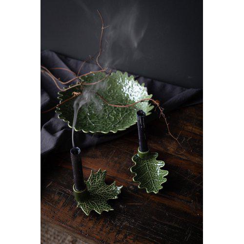 A maple leaf-shaped candle holder with a tapered design