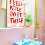 Bathroom with pink tiles, blue sink, and motivational poster.