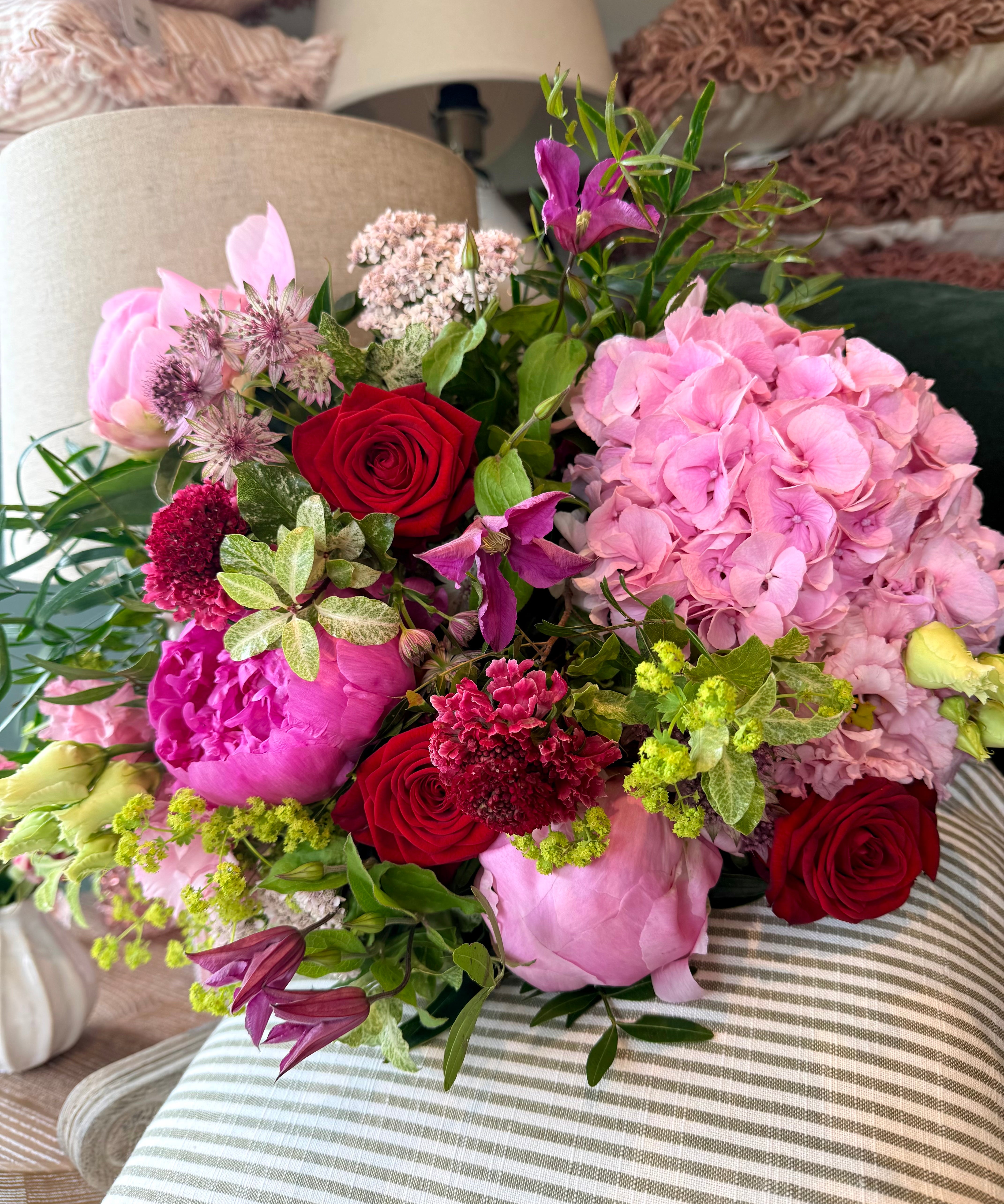 The Cherry Bomb Peony Bouquet featuring pink peonies and vibrant seasonal flowers in rich pink and cherry red tones