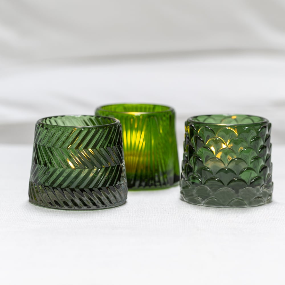 Green glass tealight holders with a geometric pattern
