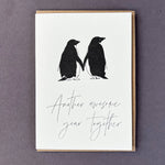 Penguin Ink Another Awesome Year Together letterpress card featuring two gentoo penguins touching flippers, printed on 100% recycled board with a tactile embossed finish.