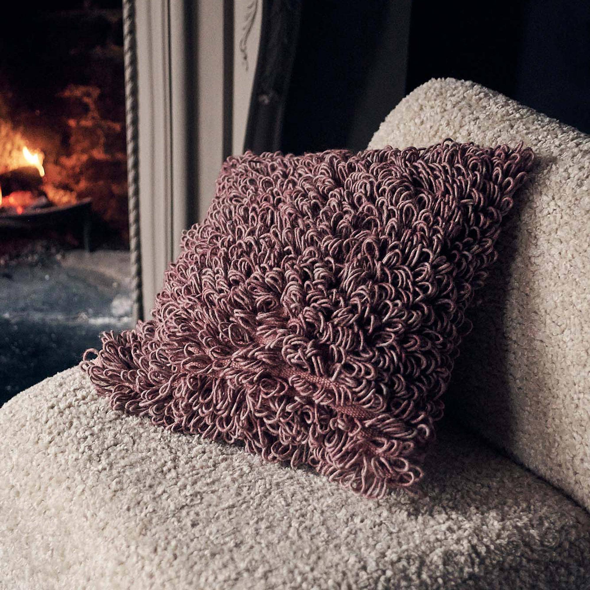 Abigail Ahern Harlem textured cushion with a soft shaggy finish in a neutral colourway, styled on a sofa for a warm, layered interior.