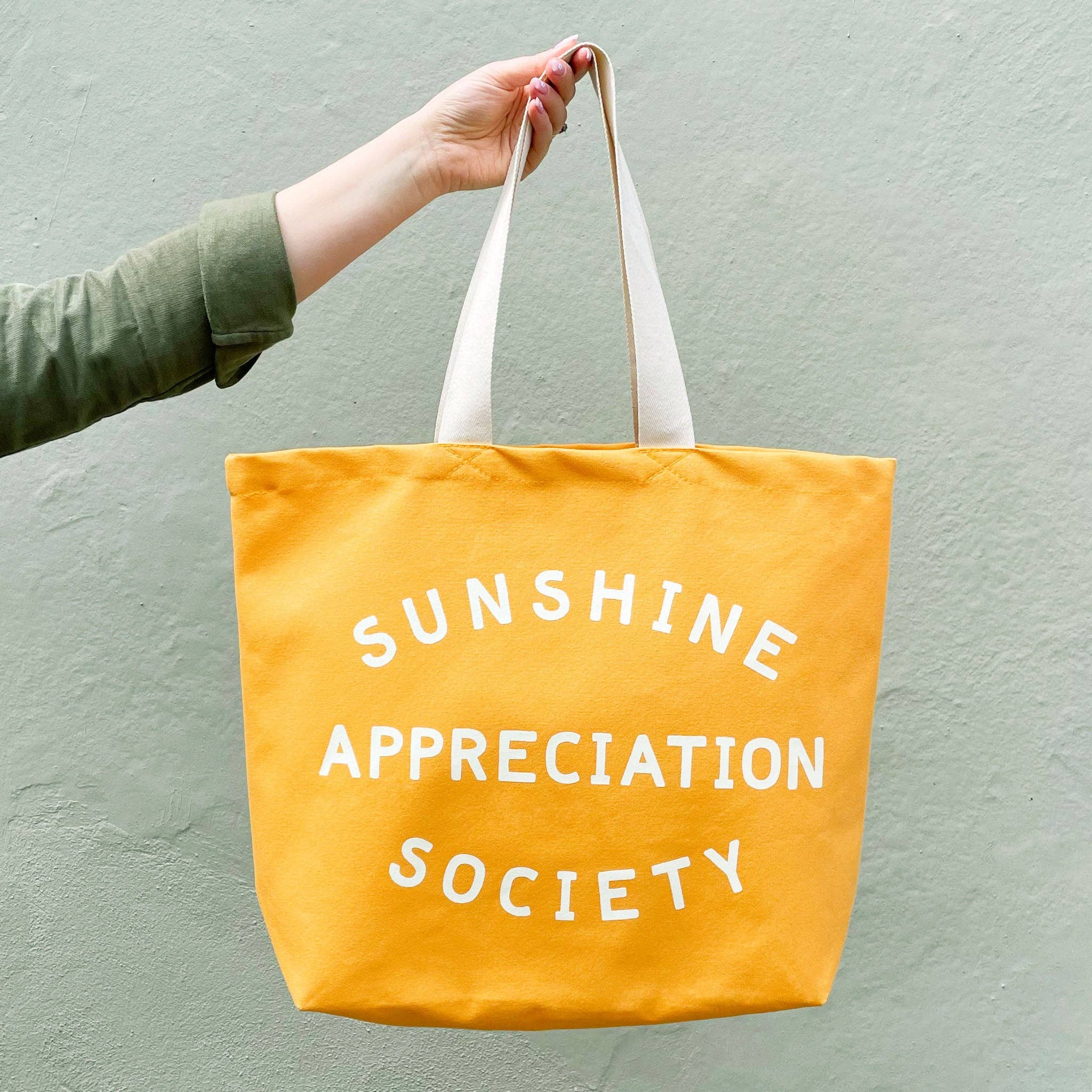 Alphabet Bags Sunshine Appreciation Society yellow cotton canvas tote bag with off-white printed design, handmade in the UK for beach days, shopping and everyday adventures.