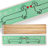 Shop the Archivist Dachshund in the Snow luxury long matchbox. A festive dog design perfect for candles, fireplaces, gifting and Christmas stockings.