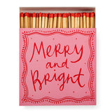 Archivist Merry & Bright luxury square matchbox featuring a pink background with festive red lettering and 125 safety matches for candles and fireplaces.
