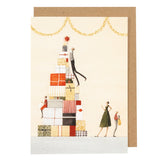 Laura Stoddart Christmas Present Pile Christmas card featuring whimsical festive illustration with kraft envelope and sustainable materials.