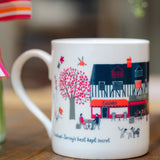 Banstead Village Life ceramic mug featuring colourful illustrations of Banstead High Street, independent shops and village landmarks by Surrey artist Lisa Tolley.