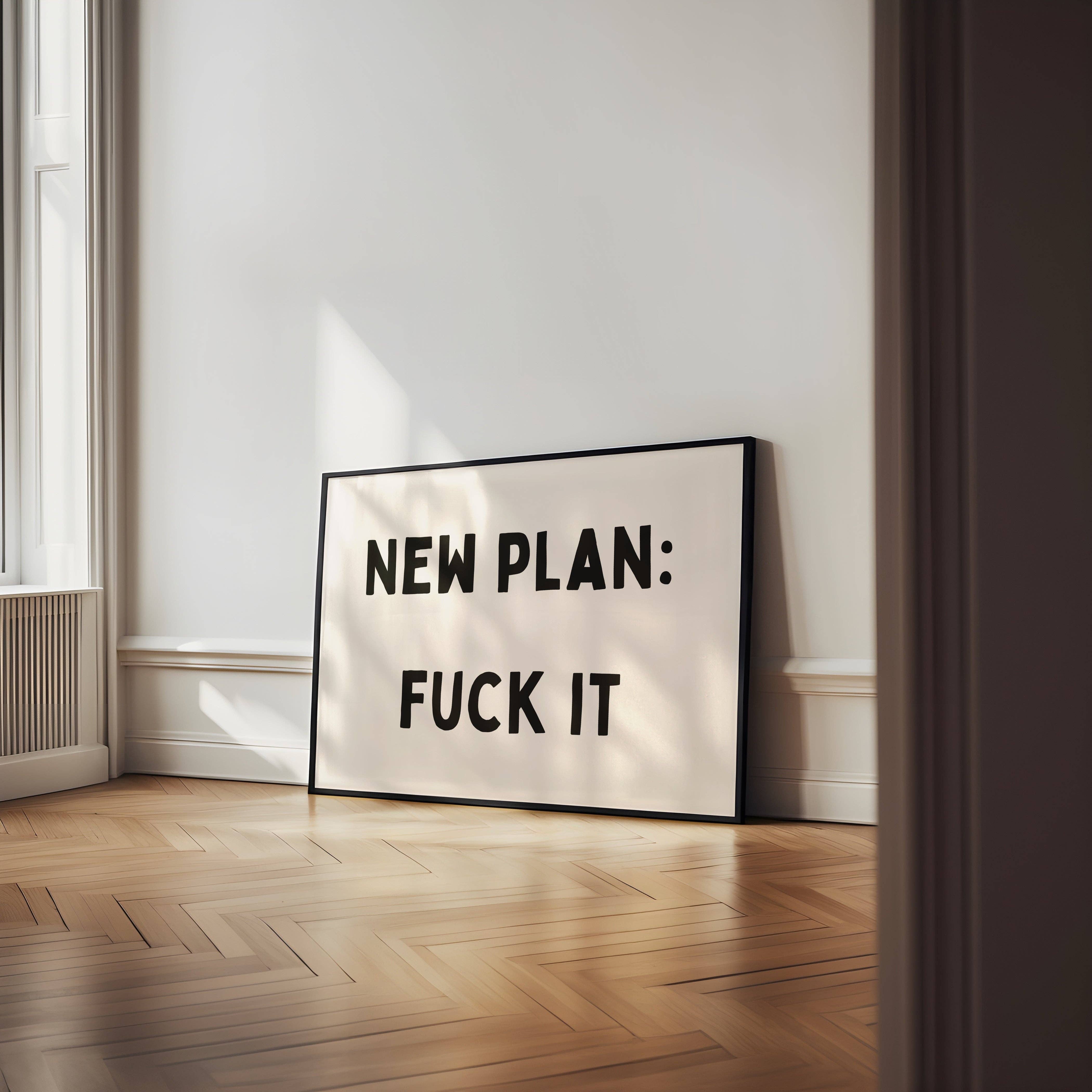 Framed poster with text 'NEW PLAN: FUCK IT' in a room with wooden floor and white walls.