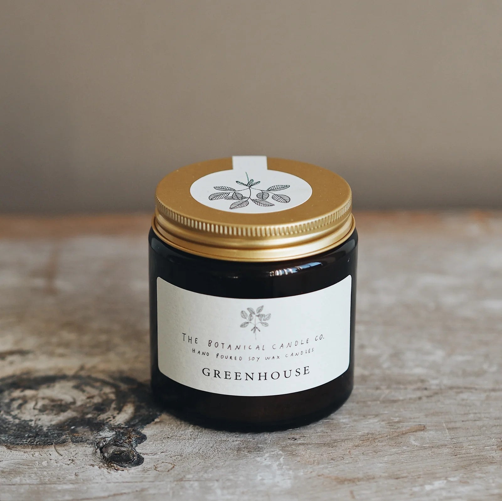 The Botanical Candle Co. Greenhouse natural soy candle in a reusable amber glass jar, hand-poured in England with fresh cut grass, basil and tomato vine fragrance.