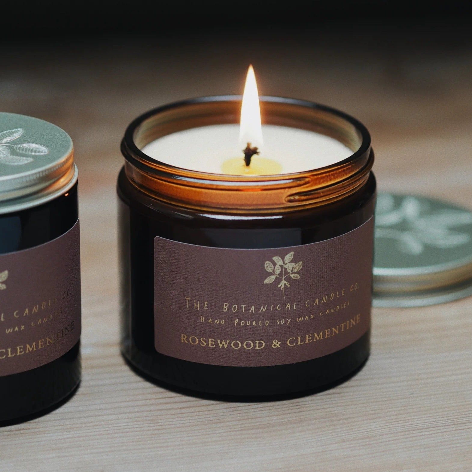The Botanical Candle Co. Mediterranean Clementine & Rosewood natural soy candle in a reusable amber glass jar, hand-poured in England.




