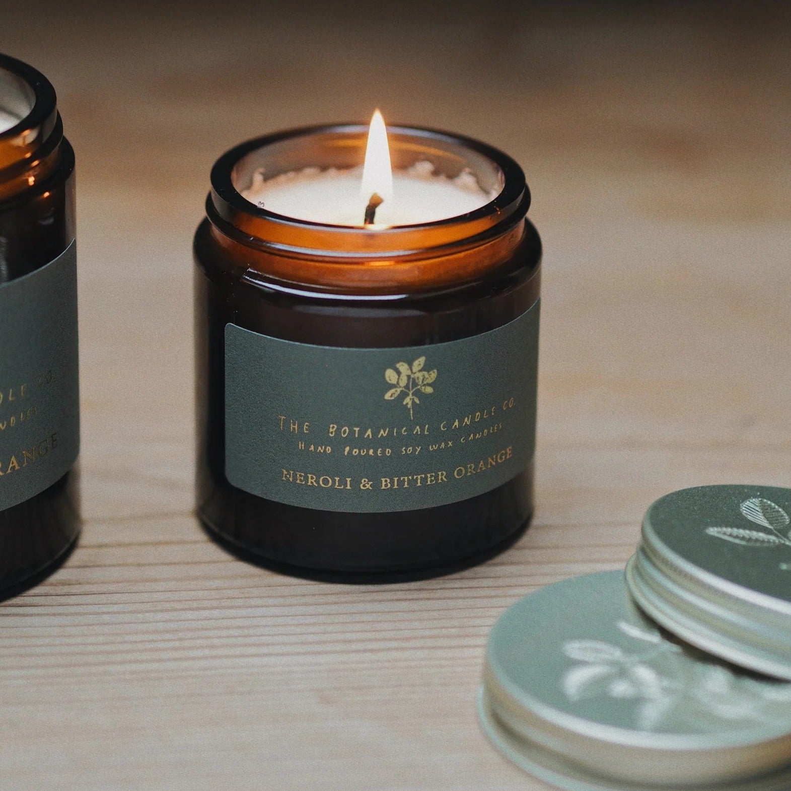 The Botanical Candle Co. Neroli & Bitter Orange natural soy candle in a reusable amber glass jar, hand-poured in England with citrus and floral essential oils.