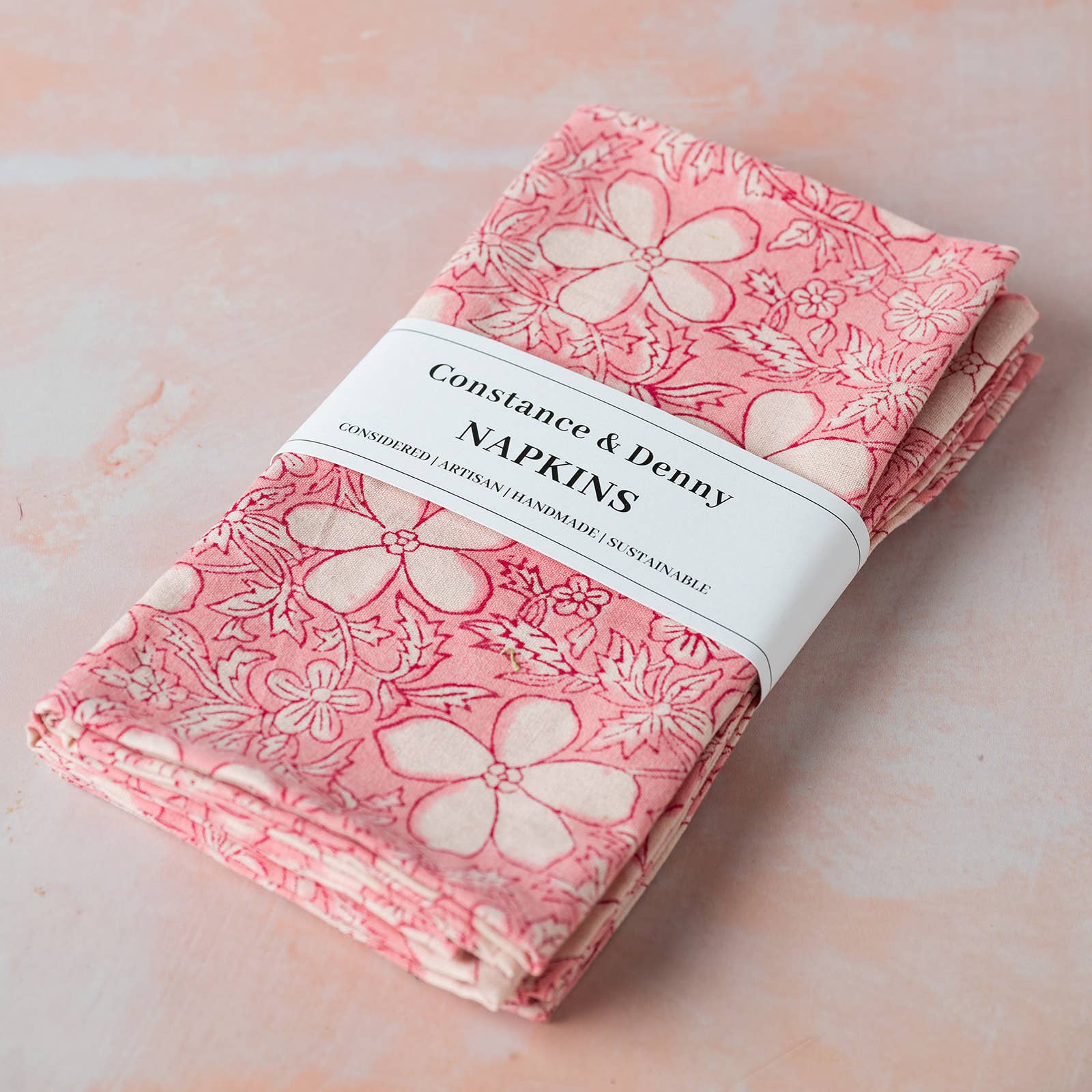 Set of four Botanical Table Rose hand block printed cotton napkins styled on an elegant dining table.