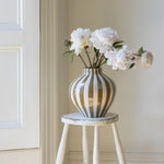 Bulbous decorative vase with warm camel vertical stripes and rounded sculptural shape