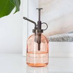 Peach glass plant mister for indoor houseplants with a minimalist design, ideal for misting tropical plants and home décor.