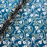 Cambridge Imprint Ivy wrapping paper in deep marine blue and acid yellow, featuring flowing ivy tendrils and contrasting berries.
