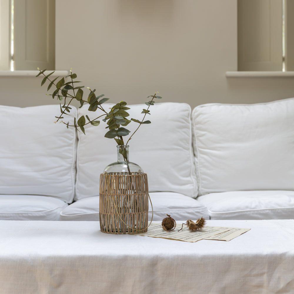 Shop our Cane Bottle Vase with Handle, combining simple glass with natural woven cane. Perfect for tall branches, fresh flowers and faux stems.