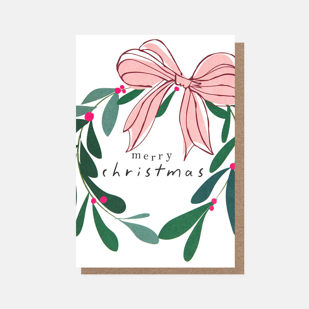 Caroline Gardner small Christmas card featuring a mistletoe wreath with red berries, a pink bow and gold foil Merry Christmas lettering on a dark background.