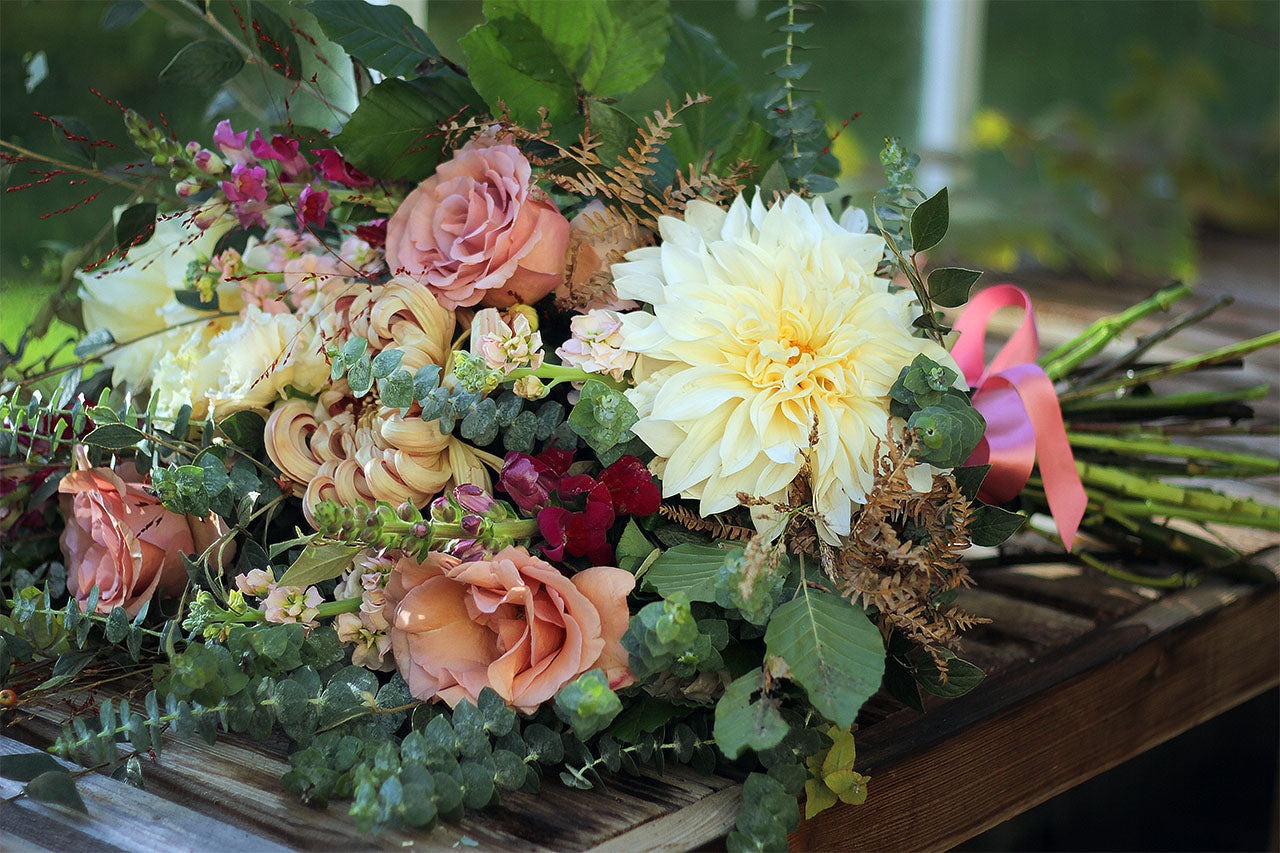 Natural hand-tied seasonal funeral sheaf with garden-style flowers and fresh foliage, handcrafted by Mad Lilies florists in Banstead, Surrey.