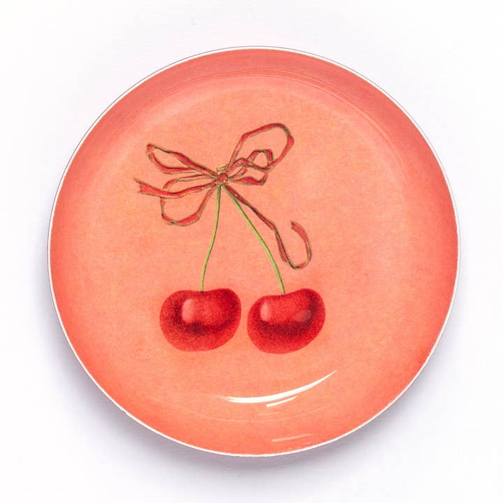 Handmade round cherry enamel trinket dish with a vintage-inspired cherry illustration on a rich red enamel background.