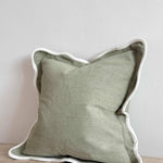 Chloe sage scalloped cushion in soft green with decorative scalloped edging, styled on a sofa in a modern country living room.