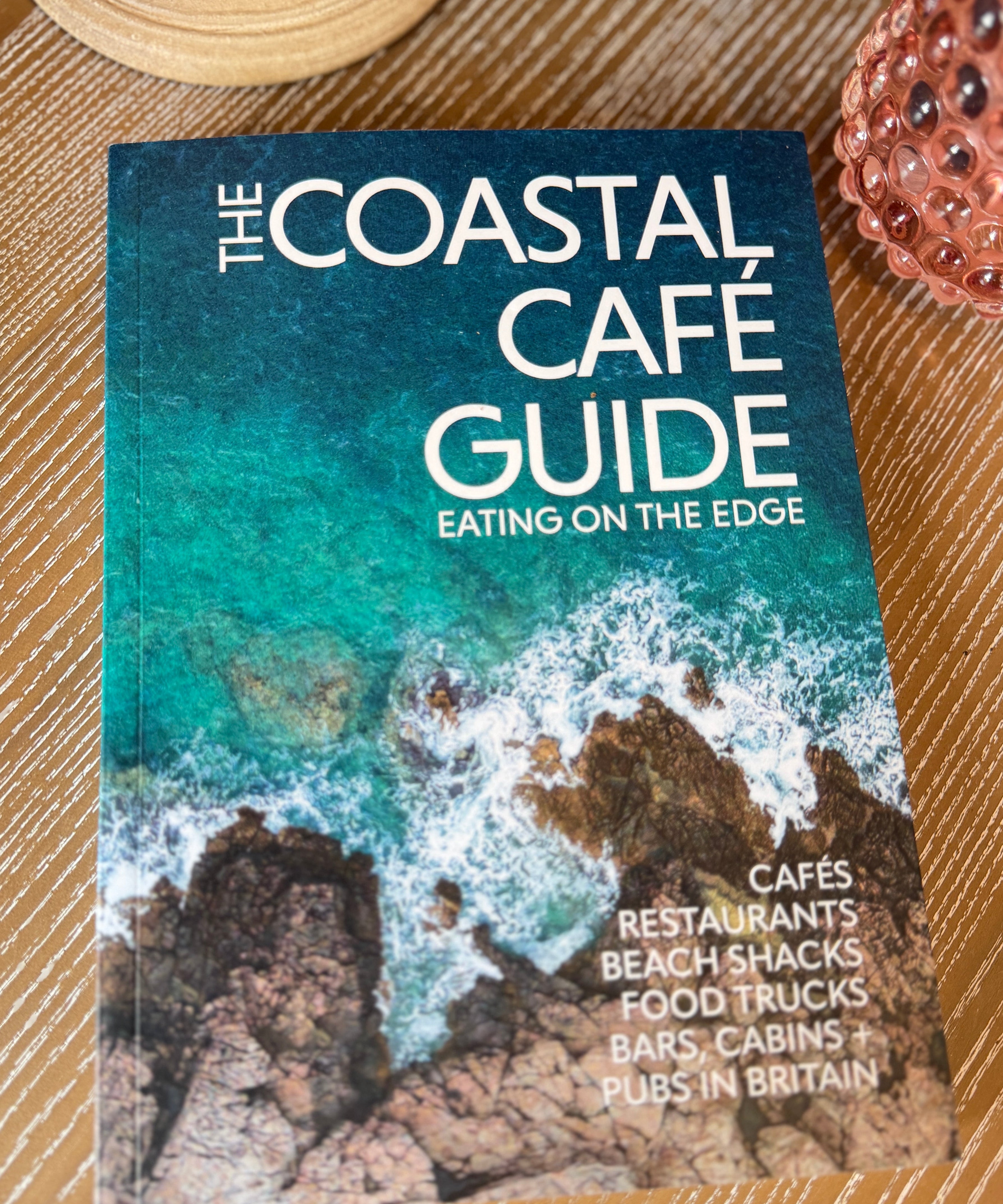 The Coastal Café Guide book featuring independent coastal cafés and restaurants around the UK