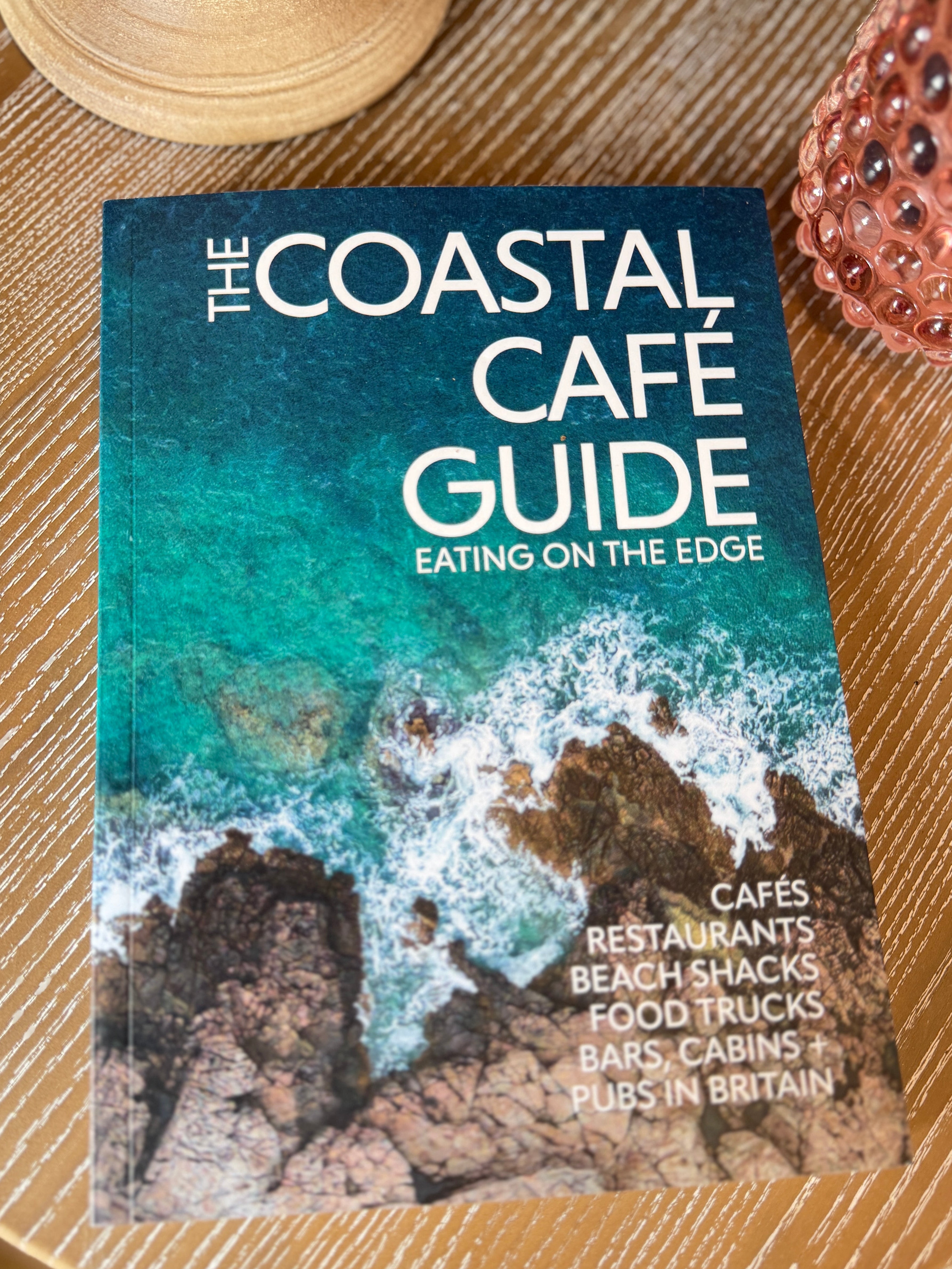 The Coastal Café Guide book featuring independent coastal cafés and restaurants around the UK