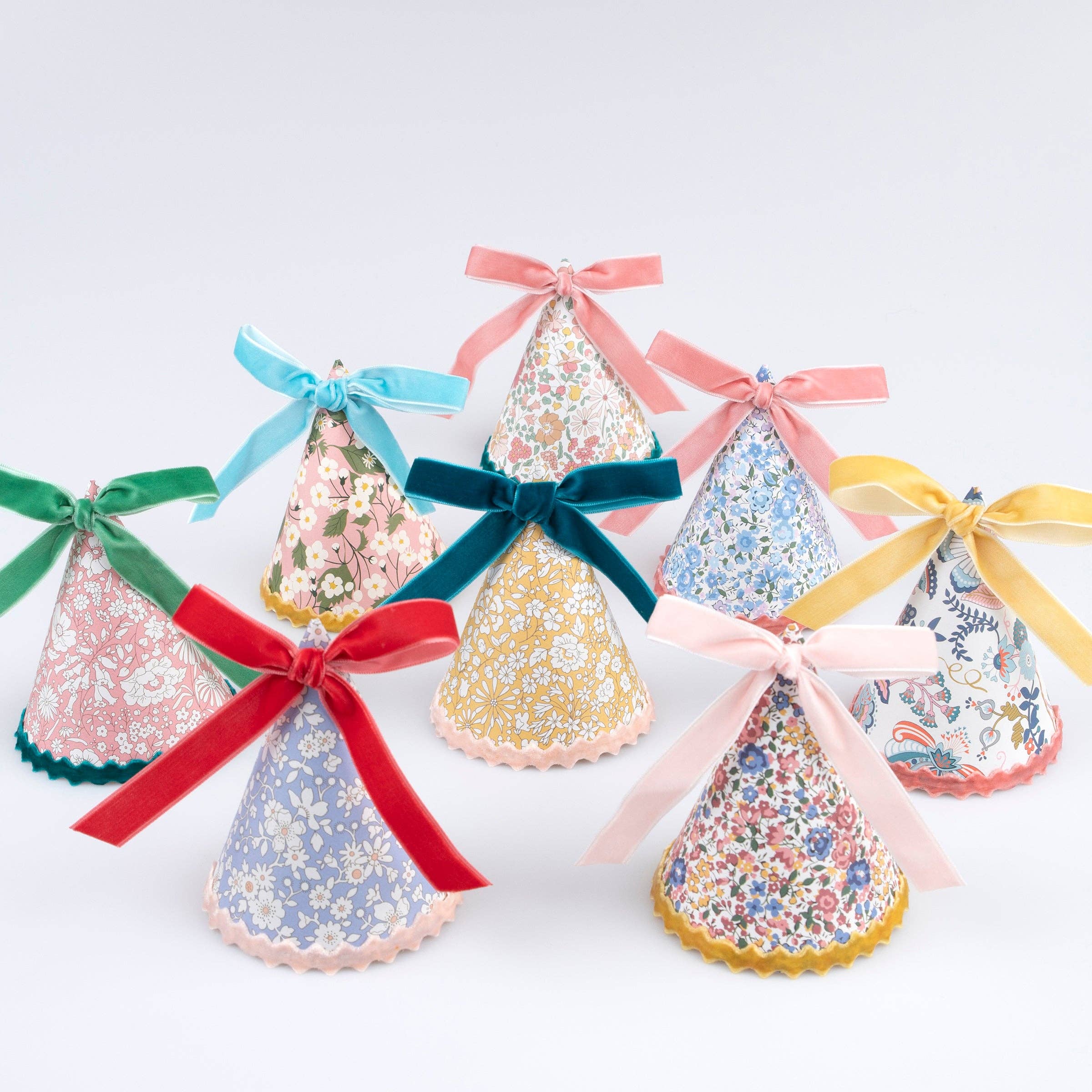 Liberty floral print party hats from the Meri Meri x Liberty collaboration with velvet ribbon bows and ricrac edging.