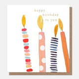 Colourful birthday card featuring hand-drawn candles decorated with spots and stripes, embossed details and gold foil.
