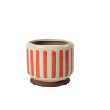 Coral crackle glaze stoneware plant pot with subtle striped texture and integrated stand for displaying indoor houseplants.