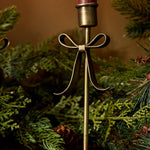 Brass Christmas candle holder with decorative bow detail for dinner candles