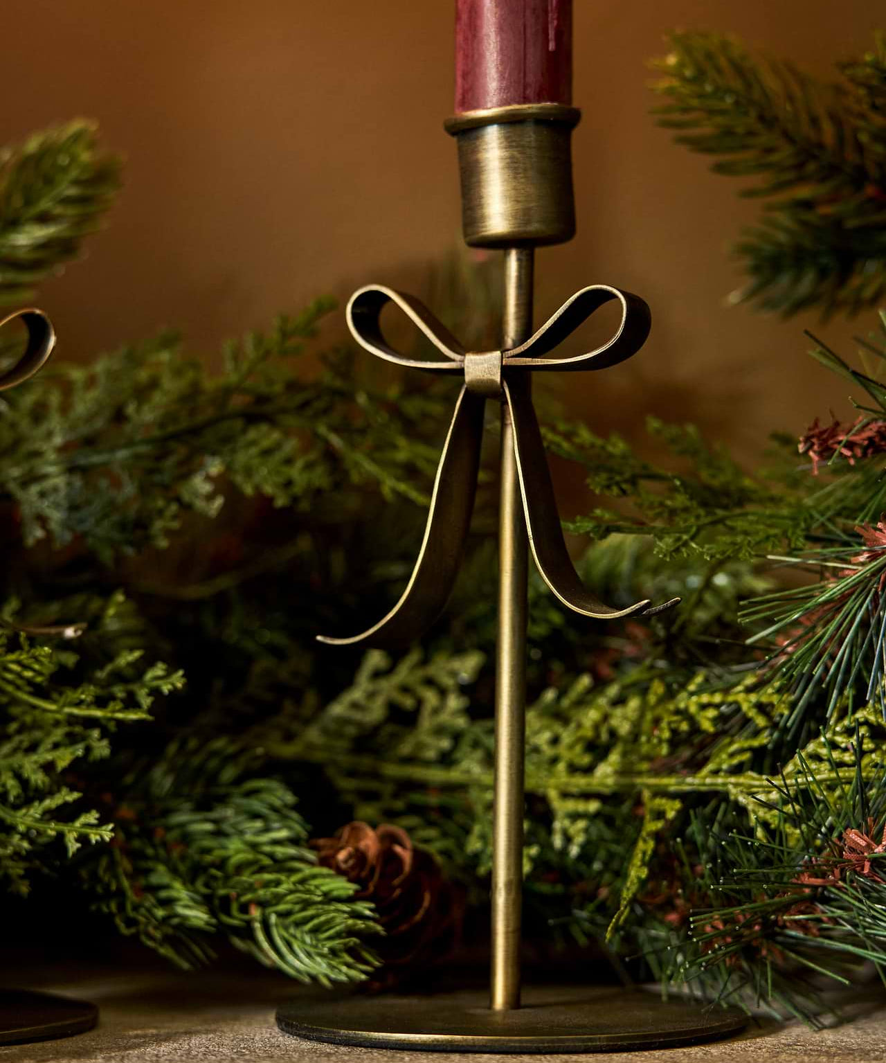 Brass Christmas candle holder with decorative bow detail for dinner candles