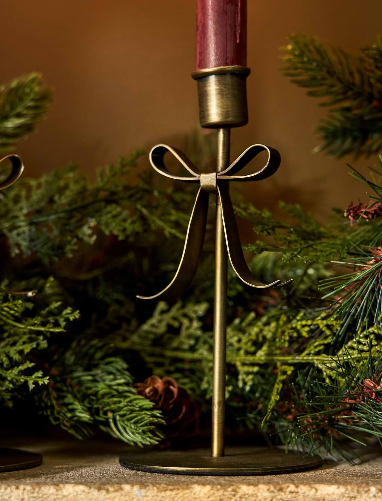 Brass Christmas candle holder with decorative bow detail for dinner candles