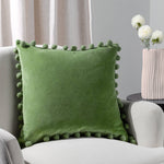Leaf green cotton velvet cushion with playful pom-pom trim and hidden zip. 100% cotton fabric, machine washable and available with feather or polyester filling.