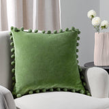 Leaf green cotton velvet cushion with playful pom-pom trim and hidden zip. 100% cotton fabric, machine washable and available with feather or polyester filling.